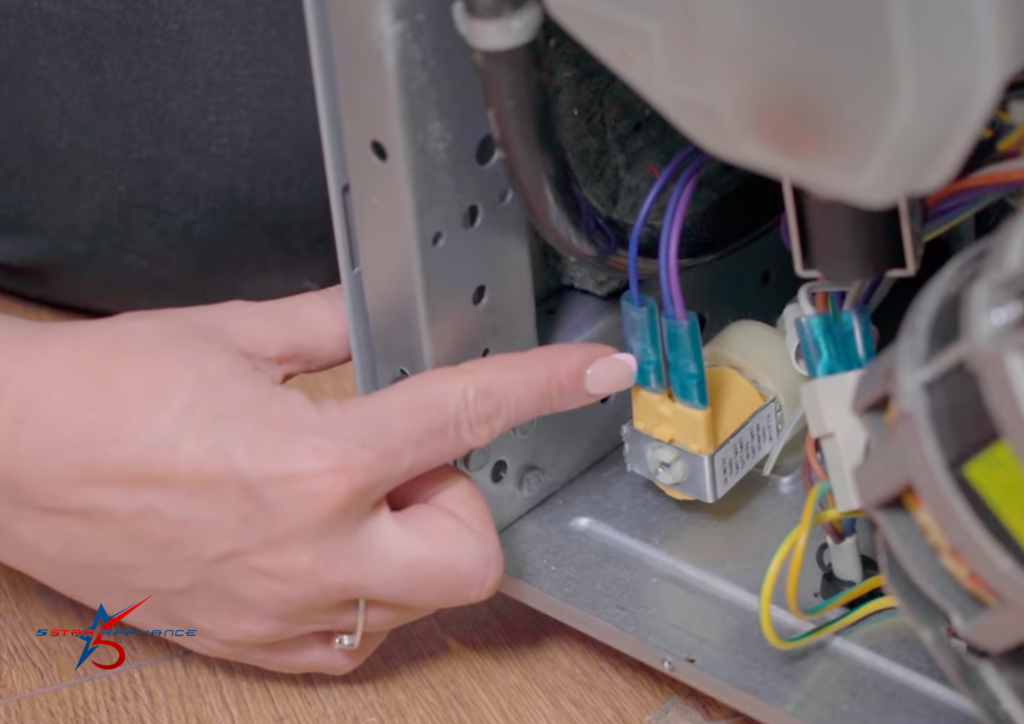 A technician pointing to a dishwasher’s water inlet valve and electrical wiring to troubleshoot filling issues and water leaks.
