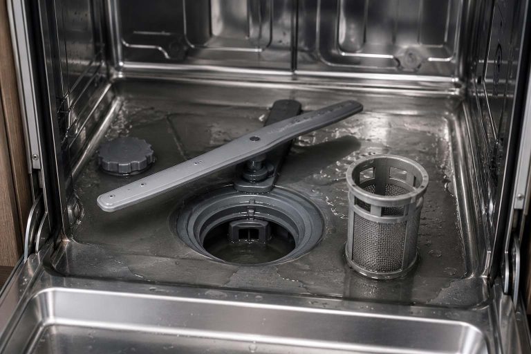 Standing water in a Samsung dishwasher tub with the cylindrical filter removed for cleaning