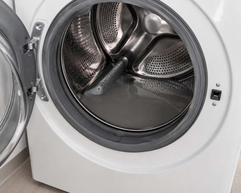 A front-load washer door open with standing gray water pooled at the bottom of the drum